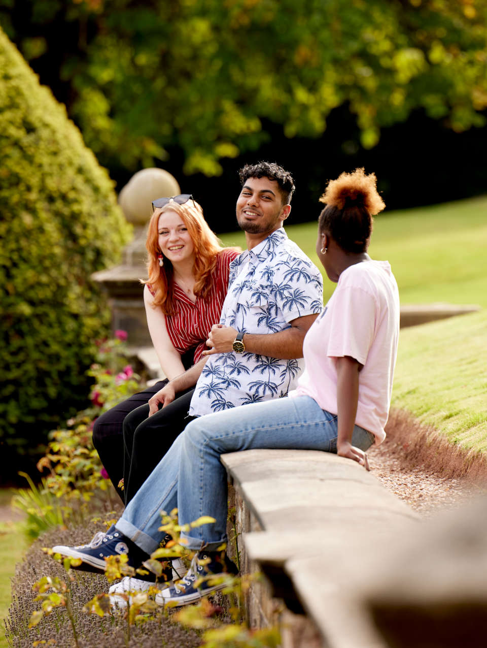 Students sat on a wall at Keele hall 